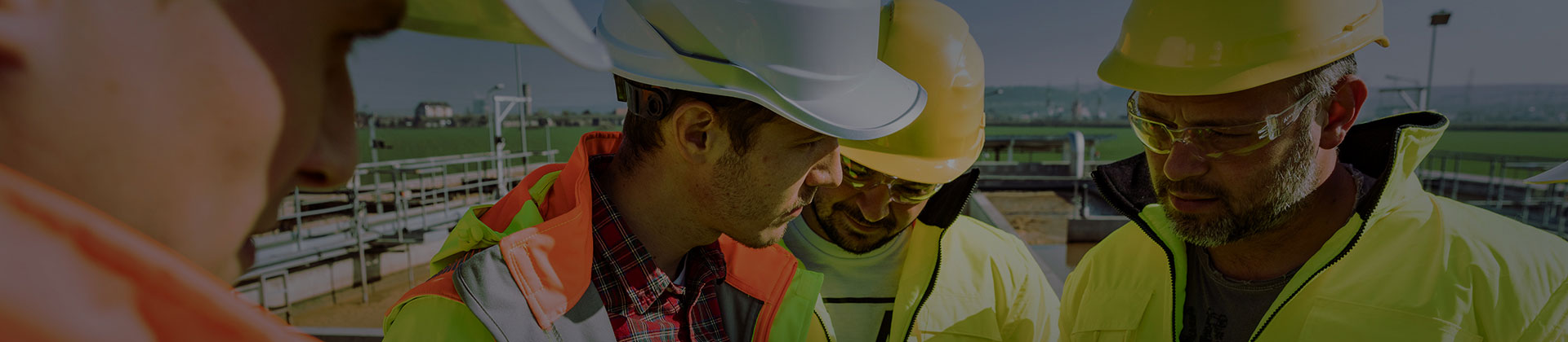 Alt text: Wastewater Treatment Plant Operators talking next to aeration tanks